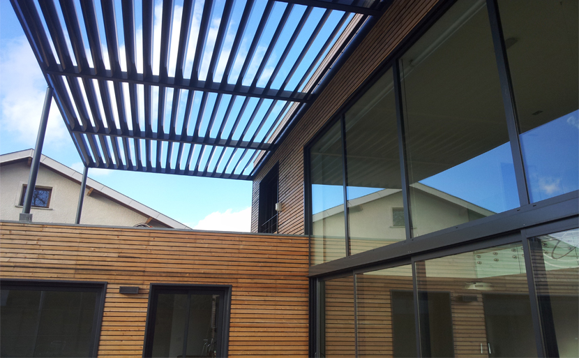 Extension contemporaine d'une maison individuelle – volume bois et béton en continuité du bâti existant